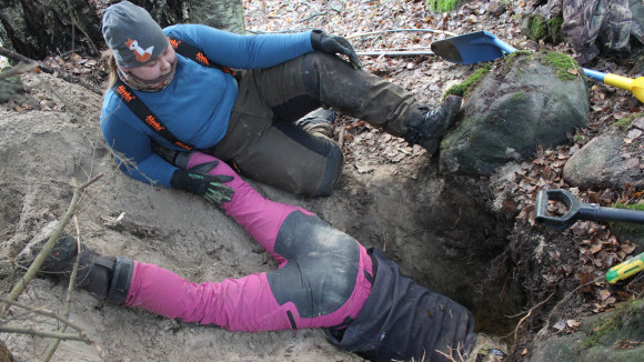  Jenni Lindqvist ja Miia Jussila kaivuu-urakan jälkeen nostamassa koiraa ja saalista pois luolasta.