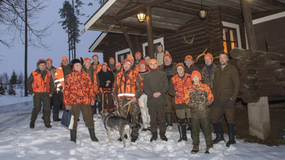 Hirvenmetsästysporukka koolla majan edessä.