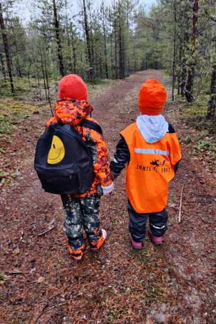 Kaksi lasta turvavaatteissa menossa passiin.