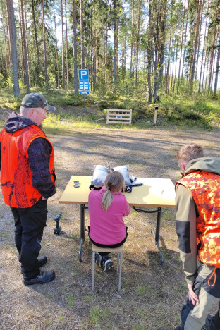 Lapsi ampuu ilma-aseella maalitauluun.