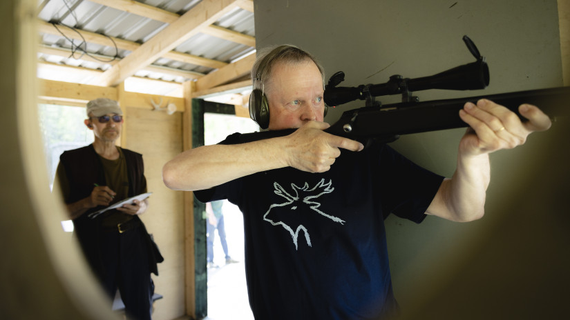 Kotiratacupissa ammutaan pienoiskiväärillä liikkuvaan hirveen. Timo Minkkinen näyttää ammunnan mallia ja Jorma Wegelius toimii suorituksen valvojana sekä tulosten kirjaajana.
