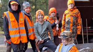 Lapset ja jahdissa saaliiksi saatu hirvi.